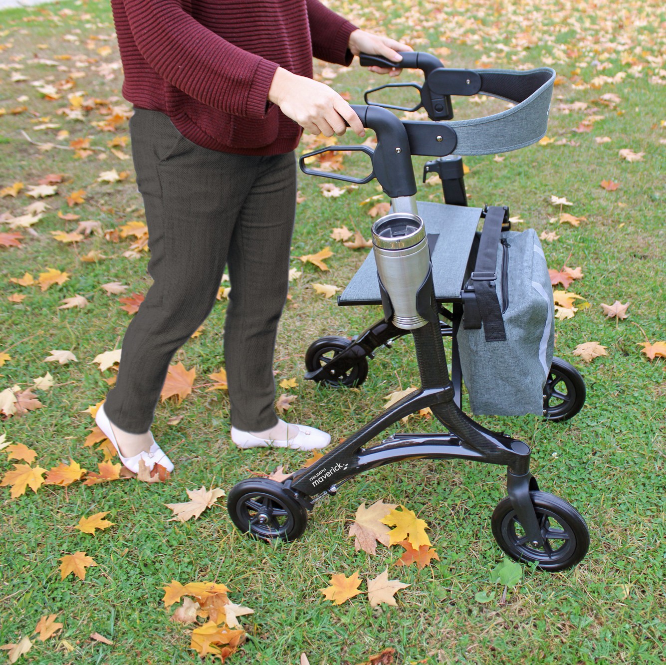 Maverick Carbon Fiber Black Rollator Walker in use on grass